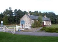 The old level crossing at Carron station in September 2004. The road provides access to the large Dalmunach distillery, located off to the right alongside the Spey. [see image 37627].<br><br>[John Furnevel 12/09/2004]