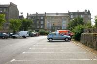 View east from the site of Leith Central station in July 2006 looking towards Easter Road. Note the surviving stonework on each side of what is now a car park serving a new supermarket built just behind the camera. Note also the tenements standing on the far side of Easter Road. The central section looks more modern, as well as being a five-storey building, whereas its neighbours only have four! The original middle section of the block was demolished in 1901 to make way for the line and bridge across Easter Road into the new station. Following closure of the station a replacement central section was built. [See image 4360]<br><br>[John Furnevel 22/07/2006]