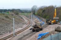 Looking north from by Merryton station to Merryton Junction. Embankment stablisation works. A road formerly crossed the line here on a bridge where the distant gentleman in the orange jacket (who was controlling construction traffic) is standing.<br><br>[Ewan Crawford 10/06/2005]