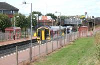 A 158 on the short trip from Anniesland to Queen Street arrives at Possilpark and Parkhouse station on 14 August 2006. The bridge in the background carries the busy A879 Balmore Road.<br><br>[John Furnevel 14/08/2006]