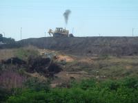 Looking North, this shows a smoky bulldozer at work helping to flatten the embankment that once carried smoky trains at the same location. The whole area is being cleared and a supermarket built at the site.  <br><br>[Graham Morgan 14/08/2006]
