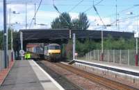 90049 brings the 14.08 Coatbridge - Crewe Basford Hall containers under the A725 Coatbank Street bridge and through Whifflet station on 24 August 2006.<br><br>[John Furnevel 24/08/2006]