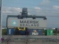 Collecting freight at WH Malcolms freight terminal at Elderslie for movement to Grangemouth. Here a 40 foot ISO box is being  lowered onto a freight flatcar.<br><br>[Graham Morgan 16/10/2006]