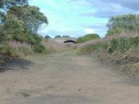 To the left the station once stood... The bridge ahead looking toward Forfar infilled to allow the Farmer wider machinary to cross. Little sign of the station to the left although on closer inspection you can see the brickwork<br><br>[Colin Harkins 31/08/2006]