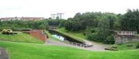 Photograph taken in the grounds of Summerlee Heritage Centre in 2006, looking north over the surviving section of the Gartsherrie Cut of the Monkland Canal. The abutment of the bridge that once carried the link from the M&K into the works, crossing over the original route of the canal, is on the far right. Coatbridge Sunnyside station lies beyond the trees in front of the Lamberton building in the left background.<br><br>[John Furnevel 29/08/2006]