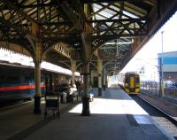 A Newcraighall - Dunblane train arrives at Waverley platform 21 on 8 September 2006 as a GNER London service makes final preparations before commencing its journey from platform 20.<br><br>[John Furnevel 08/09/2006]