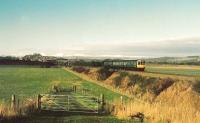 104 set heads to Stirling under the new southern bypass. To the left Stirling Castle and to the right the Wallace Monument. The mountains to the north are snowcovered.<br><br>[Brian Forbes /01/1987]
