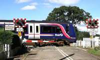 A Dundee - Edinburgh service at speed on Inchyra level crossing in the Carse of Gowrie on 6 September 2006. The cottage nameboard a reminder of why it was originally built.<br><br>[John Furnevel 06/09/2006]