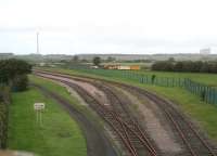 The Eastriggs military exchange sidings in 2006 looking north towards the junction with the Annan - Gretna line (the contractor's equipment is in connection with the redoubling work currently underway). The cooling towers of the decommissioned Chapelcross nuclear power station stand in the right background. The sign on the left warns <I>Police dogs on patrol</I>.<br><br>[John Furnevel 09/10/2006]