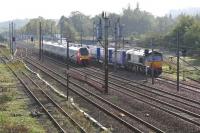 A northbound Virgin Voyager passes a static DRS 66406 with a lengthy train of Tesco containers in the down loop at Beattock on 12 October 2006.<br><br>[John Furnevel 12/10/2006]