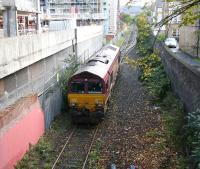 EWS 66233 arriving at Powderhall depot on 27 October 2006, passing new buildings forming part of the rapidly changing landscape in this part of the city. The locomotive is on its way to collect the 14.10 (Fridays Only) <I>Binliner</I> for Oxwellmains.<br><br>[John Furnevel 27/10/2006]