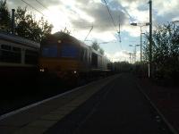 66244 passing a Class 318 unit waiting at Johnstone in the gathering gloom heading for Longannet with loaded coal hoppers <br><br>[Graham Morgan 01/11/2006]