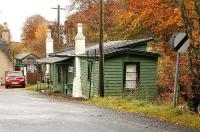 Approach to Pitcaple in November 2006 - view east towards Inveramsay. The old station building is now a shop. The support from the two substantial brick chimneys looks quite important to the structure.<br><br>[John Furnevel 08/11/2006]