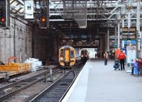 A Bathgate - Newcraighall service arriving at Waverley platform 10 via the southside crossover, after bypassing the 1205 to Plymouth boarding at 11. Part of the new Klondyke through platform can be seen between the trains.<br><br>[John Furnevel 6/12/2006]