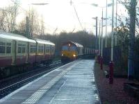 66211 about to pass through Johnstone station at a crawl, heading east with coal for Longanett PS. The Class 318 is a Largs service.<br><br>[Graham Morgan 06/12/2006]