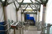 Passenger stairway between the cross-station walkway and Waverley's new platform 10 on 28 December 2006, with the associated lift behind the camera on the west side of the walkway. The south wall of the station is behind the sheet on the left. [See image 12861]<br><br>[John Furnevel 28/12/2006]