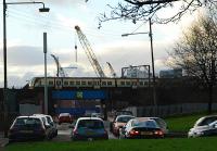 Eastbound service leaves Partick against a background of the major developments stretching for miles along the north bank of the River Clyde.<br><br>[Ewan Crawford 09/01/2006]