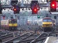 37410 hauling away the empty Caledonian Sleeper from Glasgow Central. To show how long the train was, 37410 is in the middle distance while 90018 has just cleared Platform 11.<br><br>[Graham Morgan 25/01/2007]