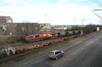 Coal empties from Cockenzie power station destined for Leith Docks entering Leith South yard on 1 March 2007 behind EWS 66085. The train is passing a line of impressive looking railway vehicles which have recently appeared alongside the yard's south wall.<br><br>[John Furnevel 01/03/2007]