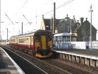 An eastbound train calls at Kirknewton station on 5 March 2007. The unique old station building, with its severe angular structure, pseudo-castellations, ball finials et al always conjures up thoughts of the aftermath of an architects night out. (The building was actually designed by Sir William Tite 1798 - 1873)  <br><br>[John Furnevel 05/03/2007]