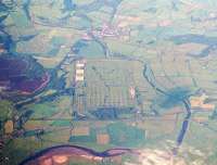 Aerial view east towards MoD Longtown, with BAD Smalmstown top left.  The WCML runs across the picture, with the remains of the triangular junction bottom left, as well as the trackbed of the old military line to Eastriggs. Longtown itself, once served by the Waverley Route, stands top centre. <br><br>[Ewan Crawford //]