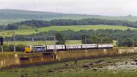 87028 <I>Lord President</I> waits on the sea wall at Craigendoran with the Royal Train. Princess Anne was on a visit to Helensburgh.<br><br>[John Robin 09/07/1981]