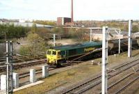 Southbound freight passing the former Viaduct Yard, beyond which stands the bridge that took the goods lines across the Caldew. The long grey building now occupies the site of Dentonholme goods depot.<br><br>[John Furnevel 18/04/2007]