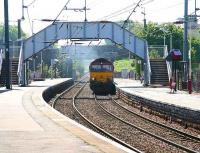 A coal train from Hunterston runs north under the footbridge linking the west side platforms at Kilwinning on 3 May. <br><br>[John Furnevel 3/05/2007]