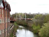 View north along the River Caldew at Willowholme on 18 April 2007 as a coal train heads south towards the station.<br><br>[John Furnevel 18/04/2007]