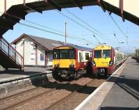 SPT liveried ScotRail services formed by 318252 and 334036 pass at Prestwick Town on 3 May 2007 with north and southbound trains running between Glasgow Central and Ayr.<br><br>[John Furnevel 03/05/2007]