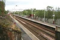 View towards Gourock from the top of the stairway linking the westbound platform and the overbridge at Bogston in April 2007. The A8 runs parallel with the line at a lower level beyond the trees on the right, with a bus stop located alongside a walkway leading up to the station.<br><br>[John Furnevel 29/04/2007]