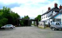 Looking north along the trackbed of the Cambrian line at Builth Road with the LNWR crossing above. The former refreshment room on the right is now a pub. 020607.<br><br>[John McIntyre 02/06/2007]