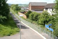 The former Maxwelltown station looking west towards Stranraer on 29 May 2007. The track has been lifted although the platforms and station building (now refurbished and occupied) can be seen behind the fence alongside what has now become the Maxwelltown Railway Path. A Scottish Oils depot occupies the site of the goods yard. [See image 4422].<br><br>[John Furnevel 29/05/2007]