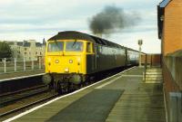 A class 47 works hard on the uphill approach to the Tay Bridge passing through Esplanade station.<br><br>[Ewan Crawford //1989]