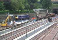 Having brought in the Edinburgh portion of the Lowland Sleeper from Carstairs, duty Sleeper locomotive 90019 emerges from platform 9 on the morning of 20 July 2007, passing a works train in 13.<br><br>[John Furnevel 20/07/2007]