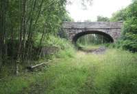 Trackbed and remains at Alyth Junction on 12 July 2007. View is North East through the road bridge carrying the B954 north towards Alyth.<br><br>[John Furnevel 12/07/2007]