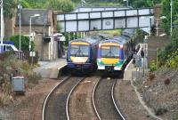 Passing strangers. View east at Polmont on 7 August 2007, with Edinburgh and Glasgow bound stopping trains at the platforms sporting old and new ScotRail liveries.<br><br>[John Furnevel 07/08/2007]