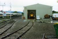 A class 37 undergoing some repairs in the temporary running shed at Muir of Ord in 1989. The coaches on the left and six 37/4s were unable to return to Inverness with the Ness Viaduct collapsed. Note the semi derelict semaphore signals.<br><br>[Ewan Crawford //1989]