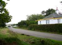 After leaving The Mound and crossing the causeway over Loch Fleet the first stop on the DLR was at Cambusavie, where a few platform remains still hide amongst the shrubbery. View south over the former level crossing on 26 August 2007, with <I>Gate House</I> opposite.<br><br>[John Furnevel 26/8/2007]