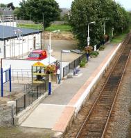 A quiet Thursday afternoon in Alness on 30 August as two schoolgirls in the shelter on the shortened platform look on in admiration as the local <I>Tarzan</I> turns in a virtuoso performance on the <I>parallel scaffolding</I>. View east towards Invergordon.<br><br>[John Furnevel 30/08/2007]