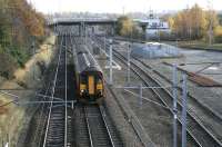 A Carlisle - Glasgow Central service at the south end of Kingmoor yard on 3 November. It has just passed the overgrown 1963 Kingmoor box standing alongside the bridge that carried the Waverley route over the WCML. The bridge is currently used by the remaining stub of the Waverley, now serving a warehouse on Kingstown industrial estate at Brunthill, just to the east. This short branch is accessed from the southwest corner of the yard via a reversal at Stainton.<br><br>[John Furnevel 03/11/2007]