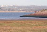 Part of the 440 yard long sea embankment that formed the southern approach to the Solway Viaduct, seen in November 2007, with the last of the cast iron piers still standing. On the north shore is the decommissioned Chapelcross nuclear power station. Although the cooling towers were demolished earlier in 2007 the four Magnox reactor halls still stand. The last train crossed the Solway Viaduct in August 1921 and it was finally demolished by Arnott Young & Co of Glasgow in 1934/5.<br><br>[John Furnevel 06/11/2007]