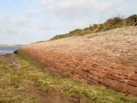 View north from Bowness towards the Solway Firth showing part of the west side of the sea embankment that once carried the railway out onto the Solway Viaduct. The image provides an indication of the amount of stone used in the construction of the 440 yard long sea embankment.<br><br>[John Furnevel 06/11/2007]