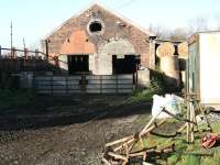 The old 2-road locomotive shed at Reedsmouth standing to the north of the station on the east side of the Border Counties line. The shed, which ended its life as a sub-shed of Blaydon (52C), has been put to use by the local farmer. The photograph, taken in November 2007, more than 40 years after closure, shows rails still present in the foreground. <br><br>[John Furnevel 05/11/2007]