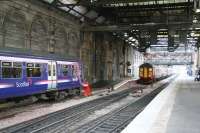 Following construction of the new platform 10 alongside the south wall at Waverley, the former station bypass line on the south side became a dead end siding entered from the east and terminating opposite the crossover. A North Berwick line 322 is stabled in this siding on 28 December 2007 while a westbound service waits to depart from platform 10.<br><br>[John Furnevel 28/12/2007]