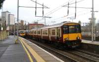 318259 leaves Motherwell with a Lanark - Dalmuir service on 2 January 2008 while a First TransPennine Express 185 waits to head south for Manchester from platform 1. <br><br>[John McIntyre 02/01/2008]