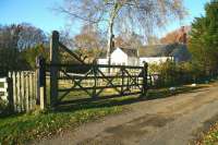 View north west over the former level crossing towards the old station house at Thorneyburn in November 2007. The station, on the Border Counties line between Kielder and Bellingham, opened in 1861 and closed in 1956. <br><br>[John Furnevel 12/11/2007]