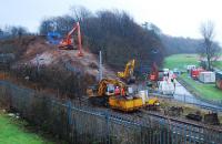 Overview of operations west of the Dalreoch tunnels. Three earthmoving cranes preparing the embankment, rail mounted crane, site office, generators and a myriad of trucks and vans (mostly out of shot).<br><br>[Ewan Crawford 18/01/2007]