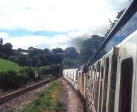 A class 37 with a train of clay hoppers from Moorswater depot pushes a failed DMU off the Looe branch up the bank from Coombe Junction towards Liskeard in 1991.<br><br>[Ian Dinmore //1991]