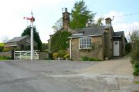 View northwest over the former station and level crossing at Romaldkirk. The old station, seen here in May 2006, stood on the Tees Valley Railway, which ran from the junction with the Stainmore line at Barnard Castle to a spacious rural terminus at Middleton-in-Teesdale. The line was closed in 1964.<br><br>[John Furnevel 11/05/2006]